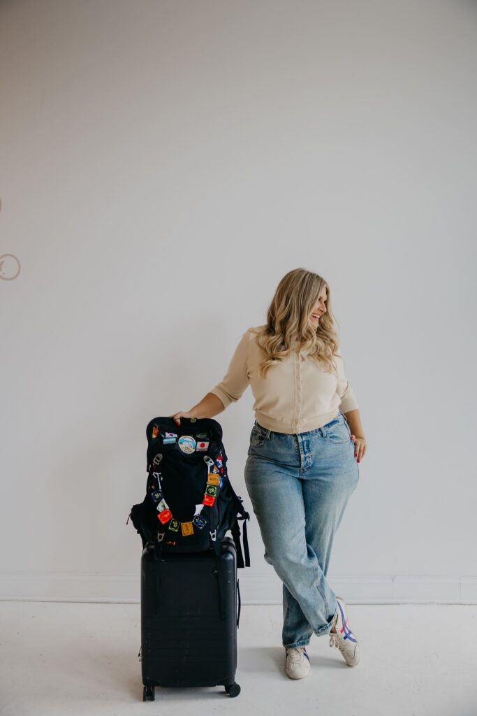 Real estate coach walking with pin-covered black suitcase in studio