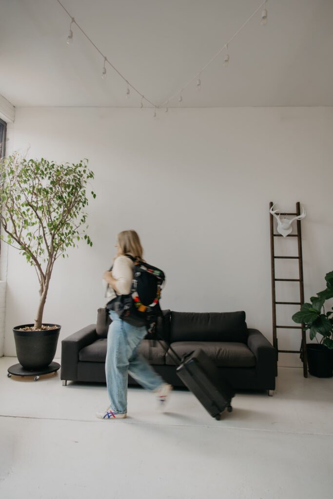 Real estate coach walking with suitcase through sunlit studio loft