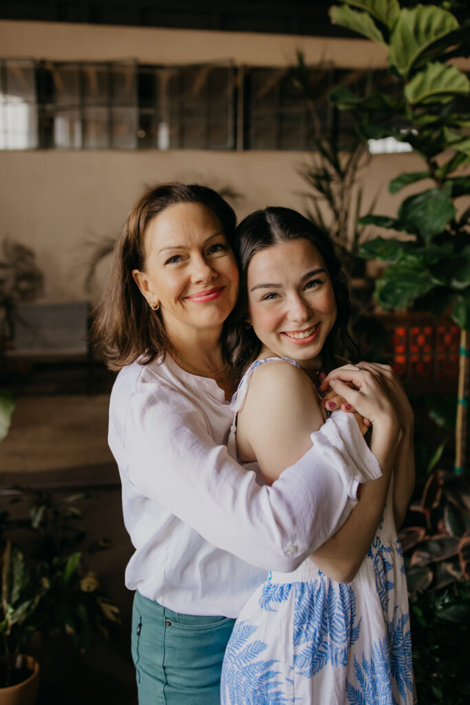 Minneapolis senior and her mom embracing and smiling during senior photography session with mom