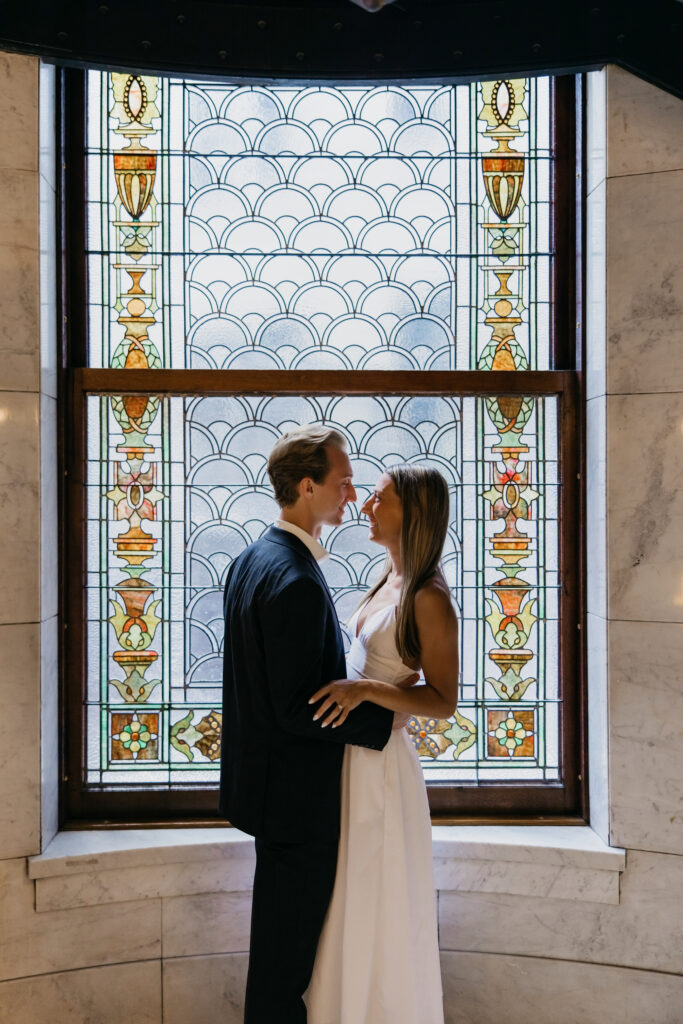 Couple face to face in front of a stained glass window