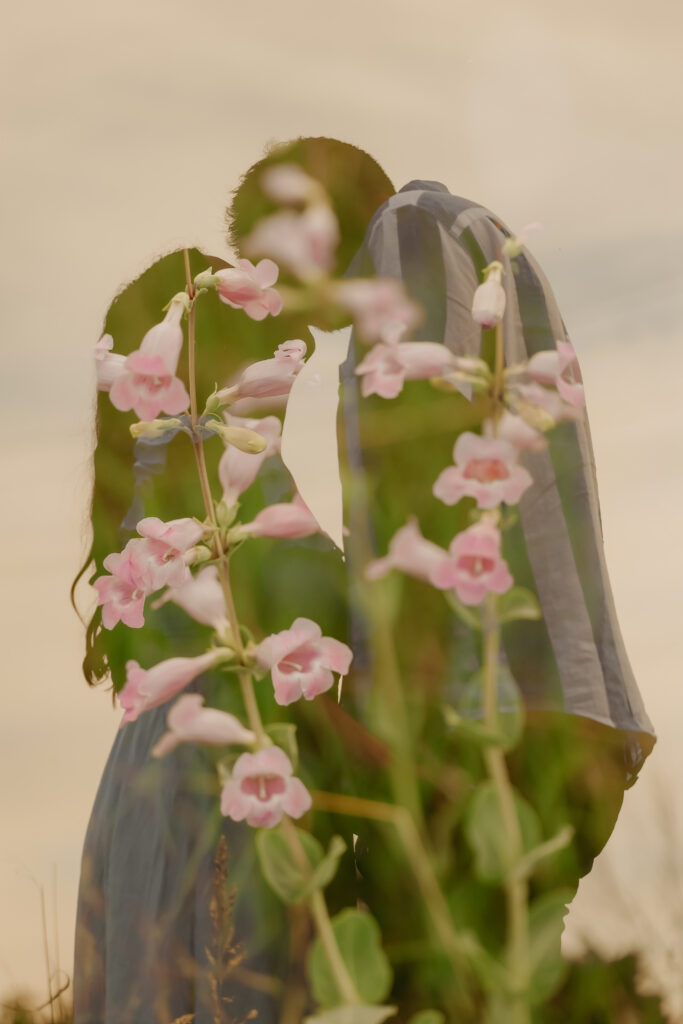 Double exposure of couple about to kiss blended with pink flowers