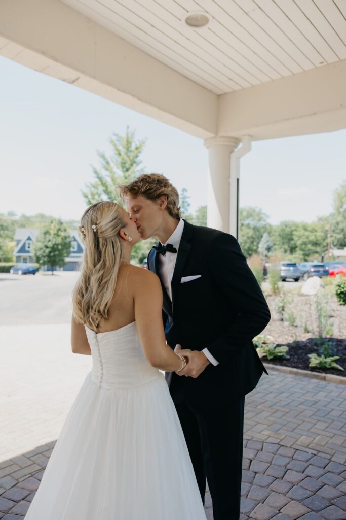 Bride and groom kissing under the covered entrance at Minneapolis Golf Club