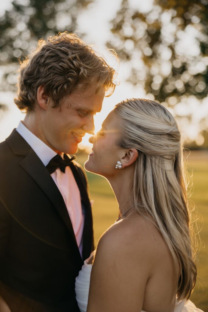 Bride and groom nose to nose smiling in golden light at Minneapolis Golf Club
