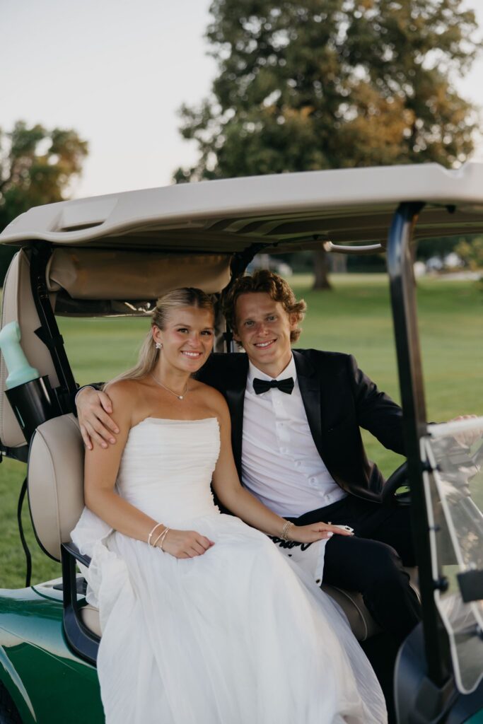 Bride and groom kissing while riding in a golf cart at Minneapolis Golf Club
