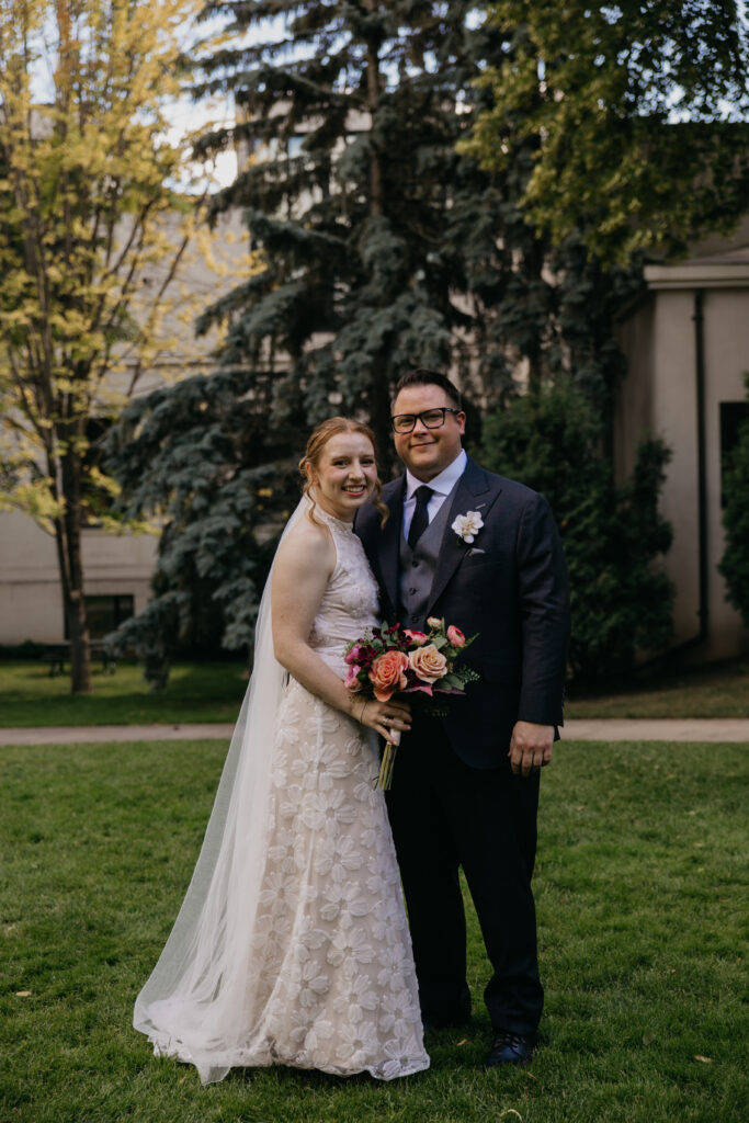 Bride and groom embrace smiling on the lawn outside the Minneapolis Institute of Art