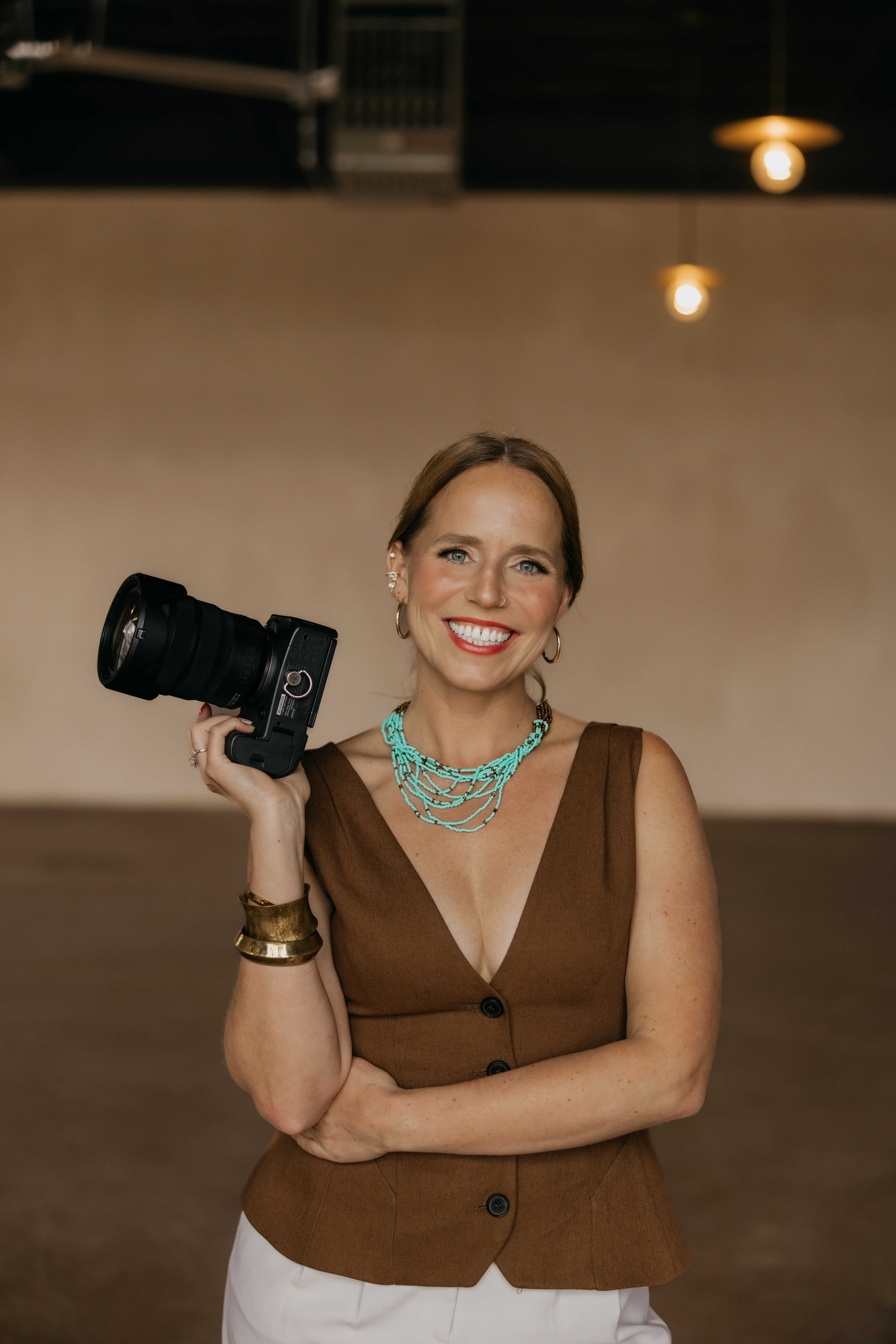 Mycah Bain, an example of personal branding for business owners, holding her camera in a Minneapolis studio