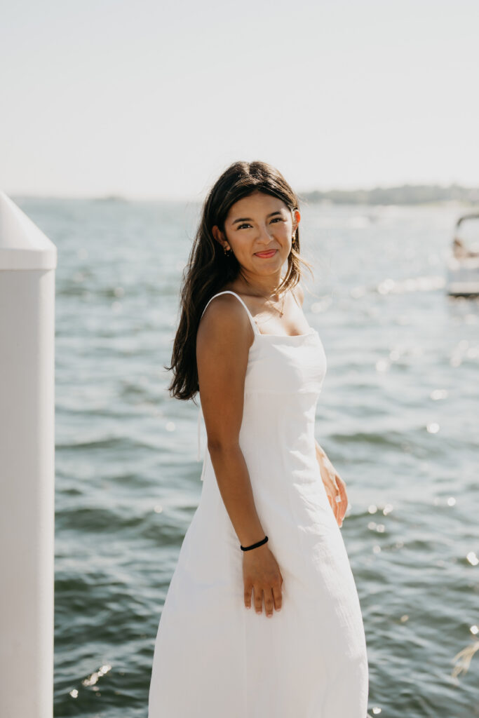 Natalia standing in a white dress with the lake in the background