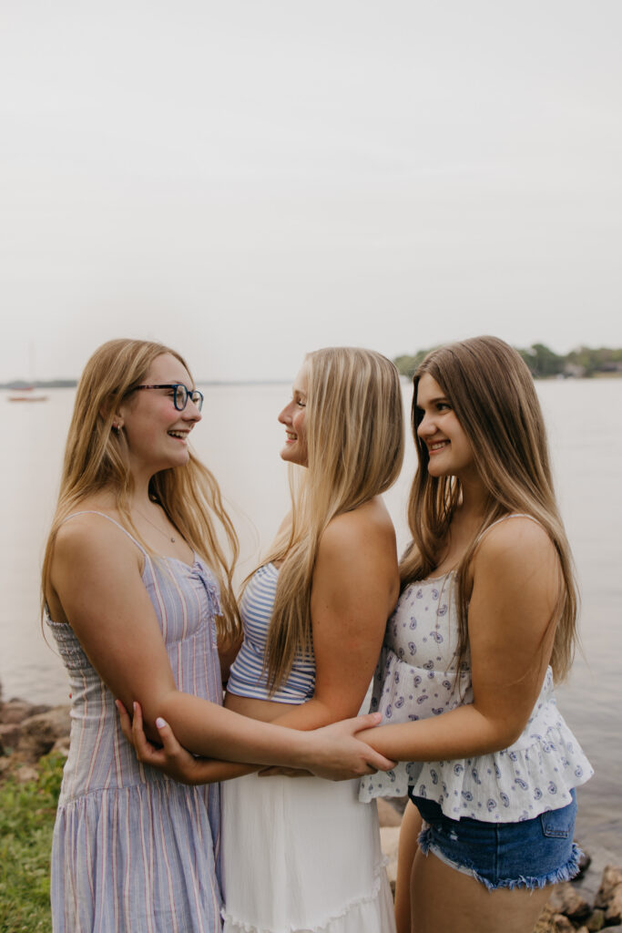 senior photos with friends laughing together during a candid lakeside moment