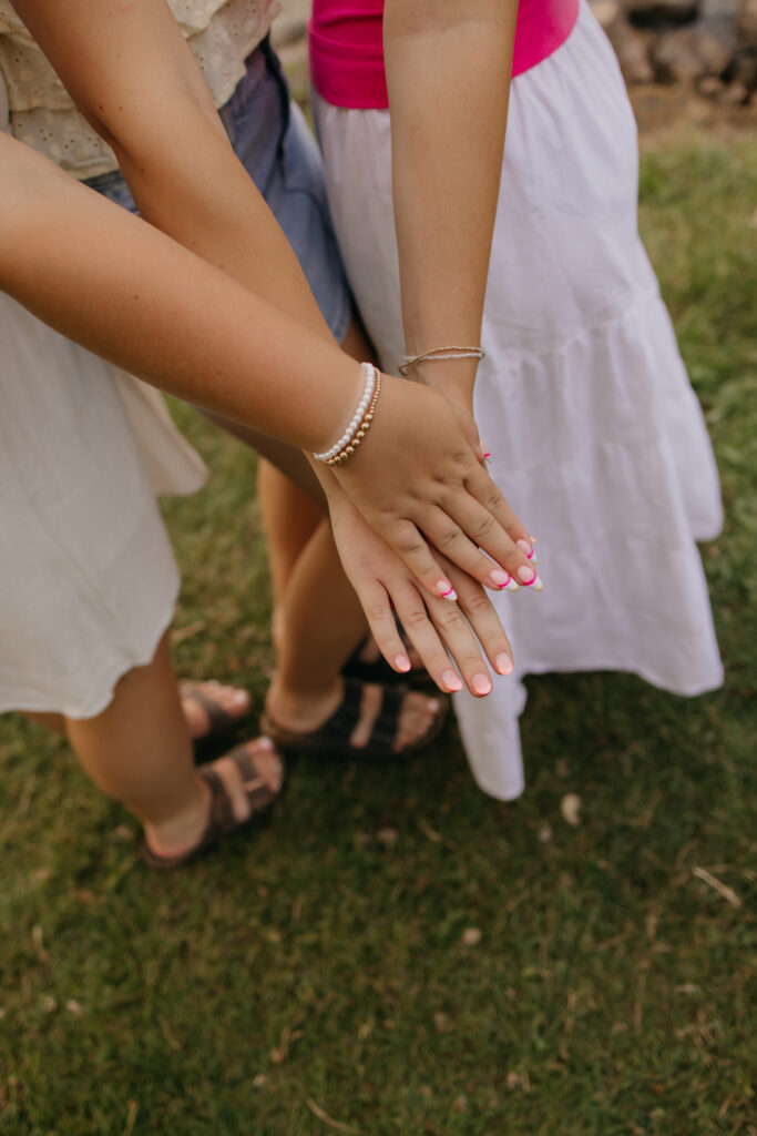 close-up of friends' hands stacked together in a group cheer