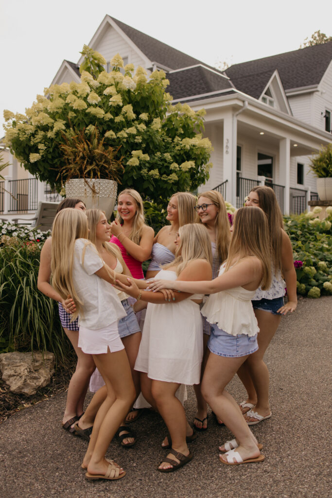 senior friend group photoshoot of friends circled up holding hands