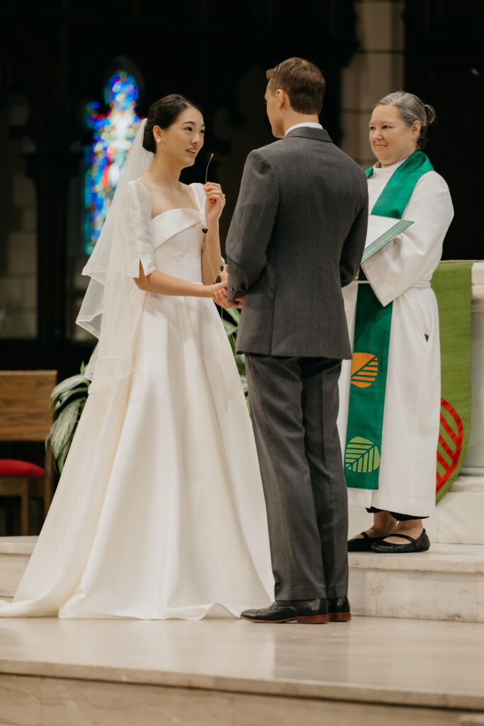 Bride and groom exchange vows in front of the officiant during their Central Lutheran Church wedding