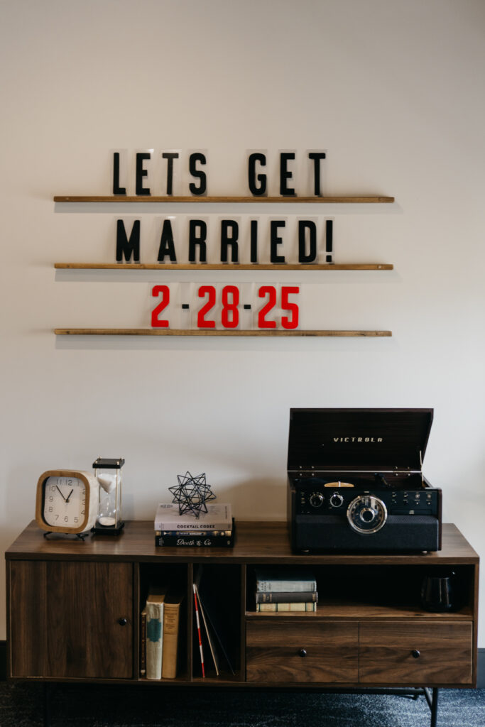 "Let's Get Married" letter board sign with the wedding date on a record console