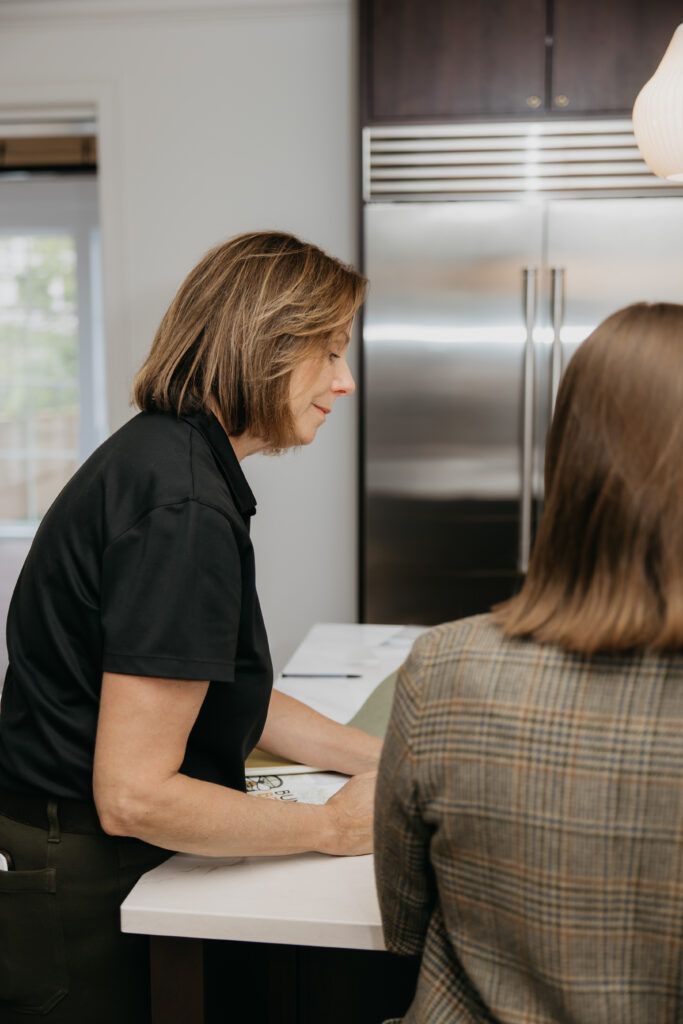 Bumble Bee Blinds team member reviewing paperwork at a kitchen island with a colleague