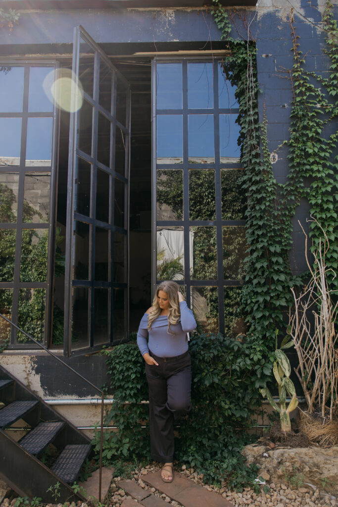 Caitlin Weseman outside a vine-covered building with steel windows during her Minneapolis brand session