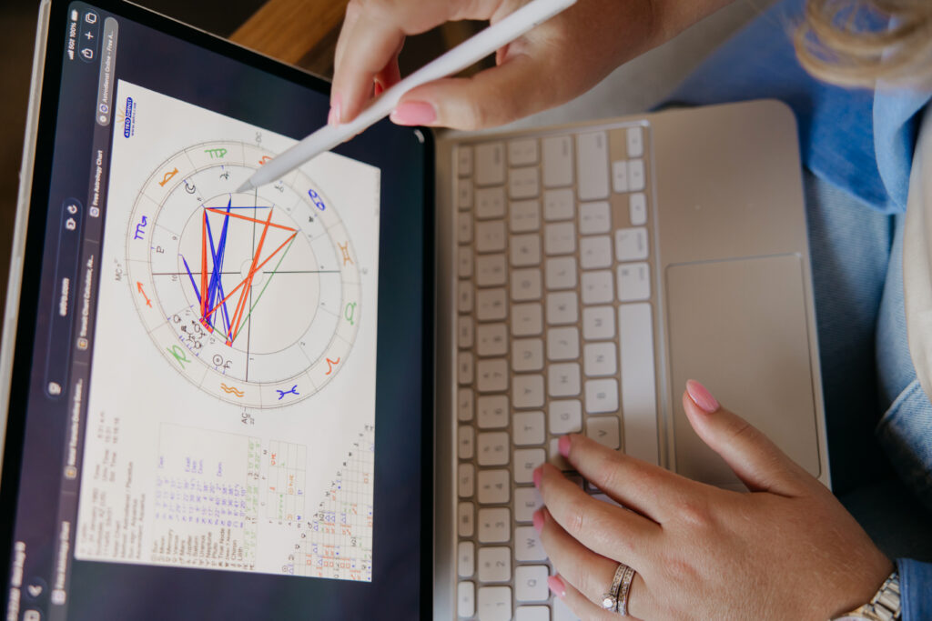Close-up of a birth chart on a tablet with a stylus and keyboard