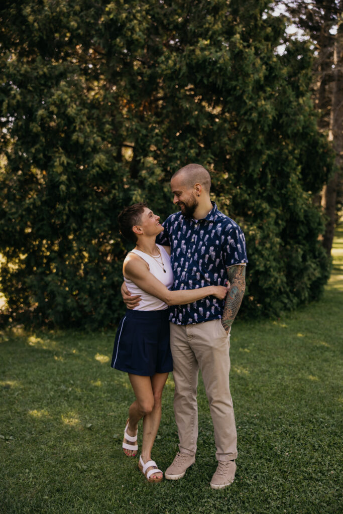 Young couple sharing a close, smiling moment during an outdoor family reunion session
