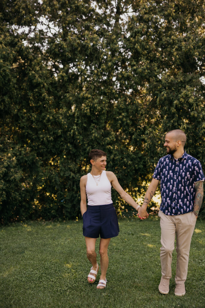 Young couple holding hands and walking together during golden hour at a family reunion