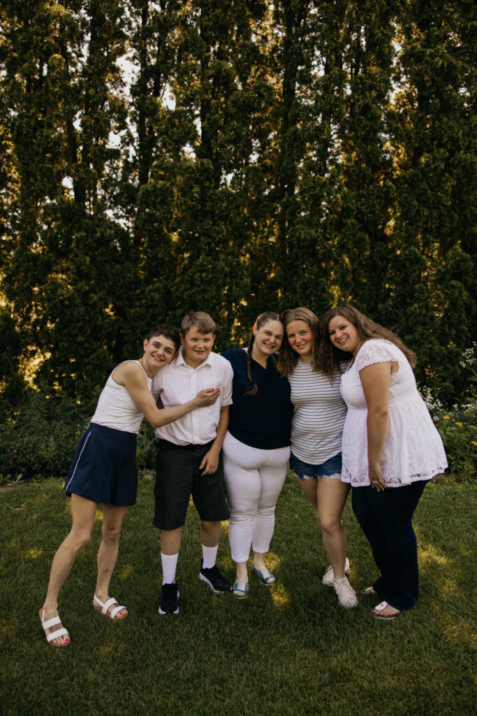 Siblings and cousins laughing together in a group huddle during a family reunion session