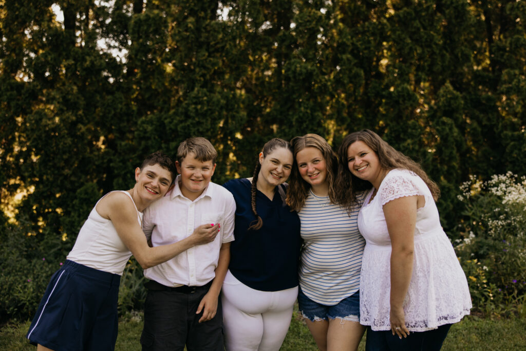 Siblings and cousins laughing together with arms around each other at a family reunion