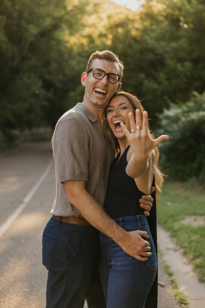 Newly engaged woman laughing and showing her ring outdoors in Minneapolis