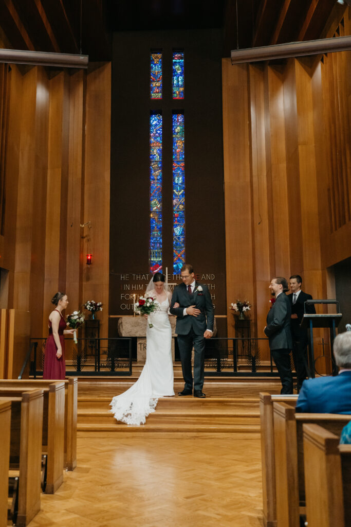 Bride and groom share a laugh at the altar during their Mount Olive Lutheran Church ceremony