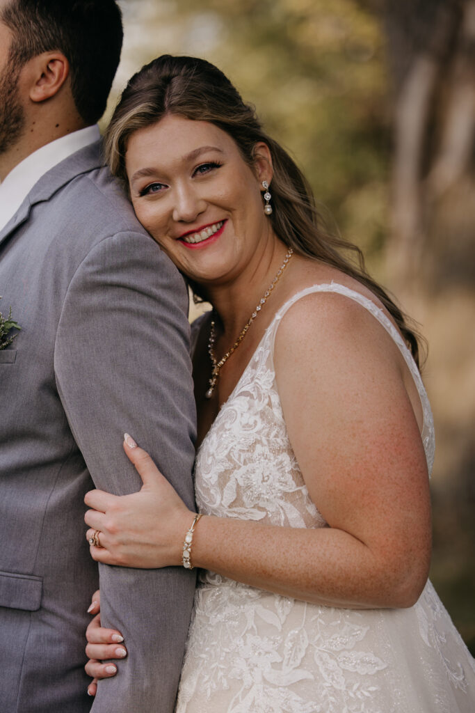 Bride smiles close up with a guest during the ceremony