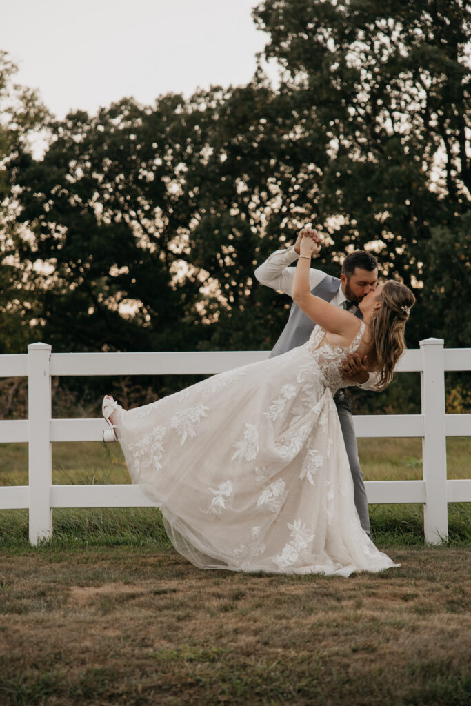 Groom dips the bride for a kiss during sunset portraits at the Cottage Grove venue