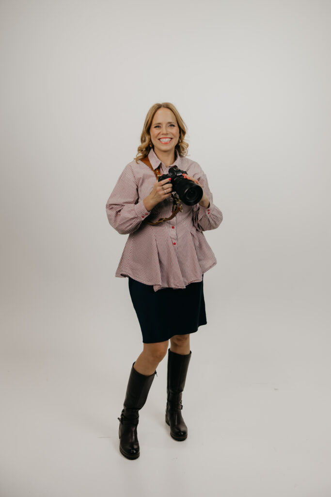 Creative business owner in a studio holding a camera during a brand photography session