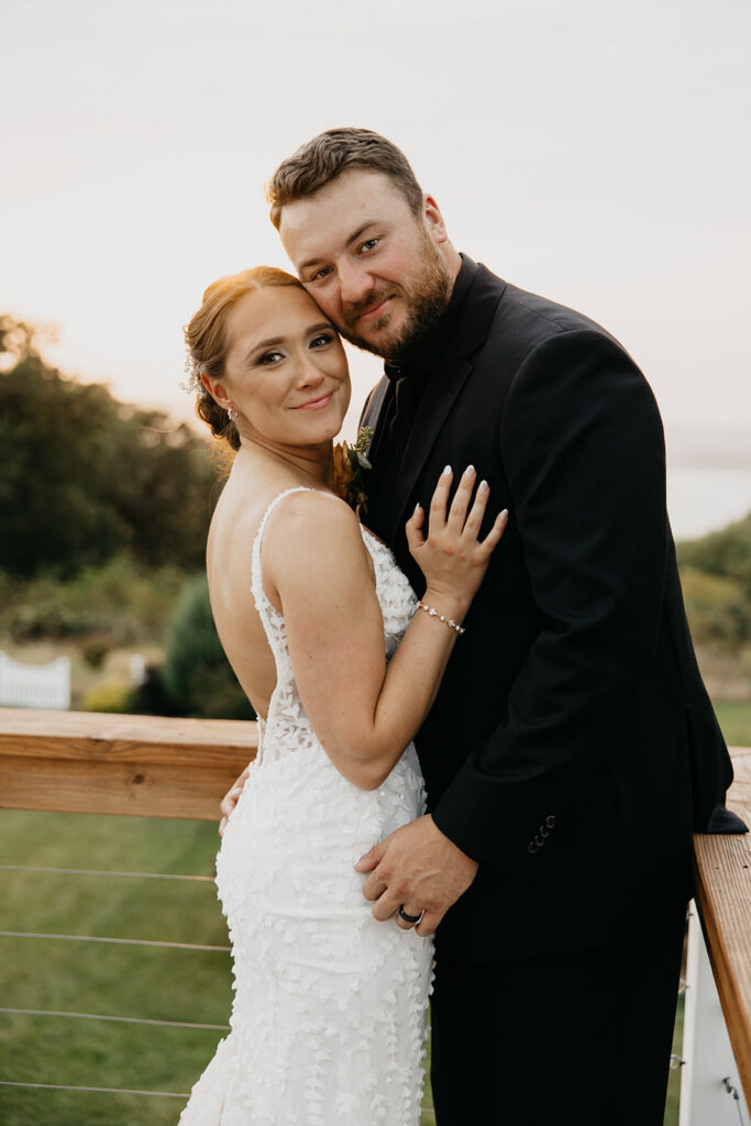 Bride and groom smiling forehead to forehead on the reception deck