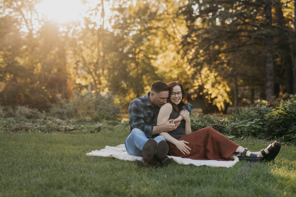 Couple sitting together on a blanket in a sunlit garden