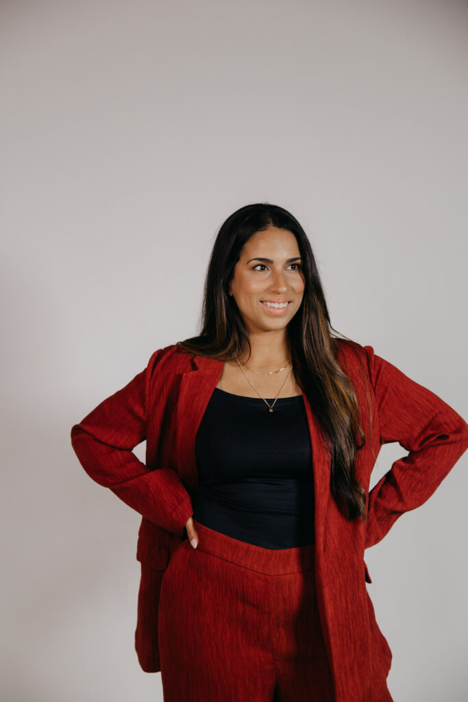 Business headshots in Minneapolis: Tatiana Budney standing in a red duster suit, hands on hips