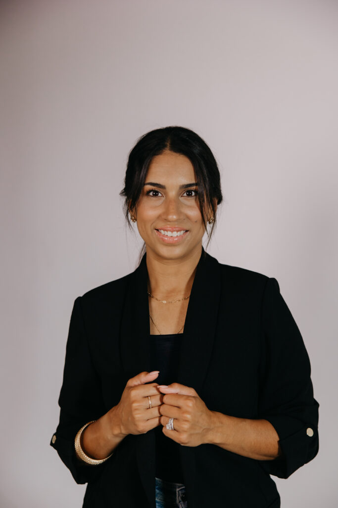 Personal branding photography for entrepreneurs: Tatiana Budney in a black blazer, hands clasped, smiling