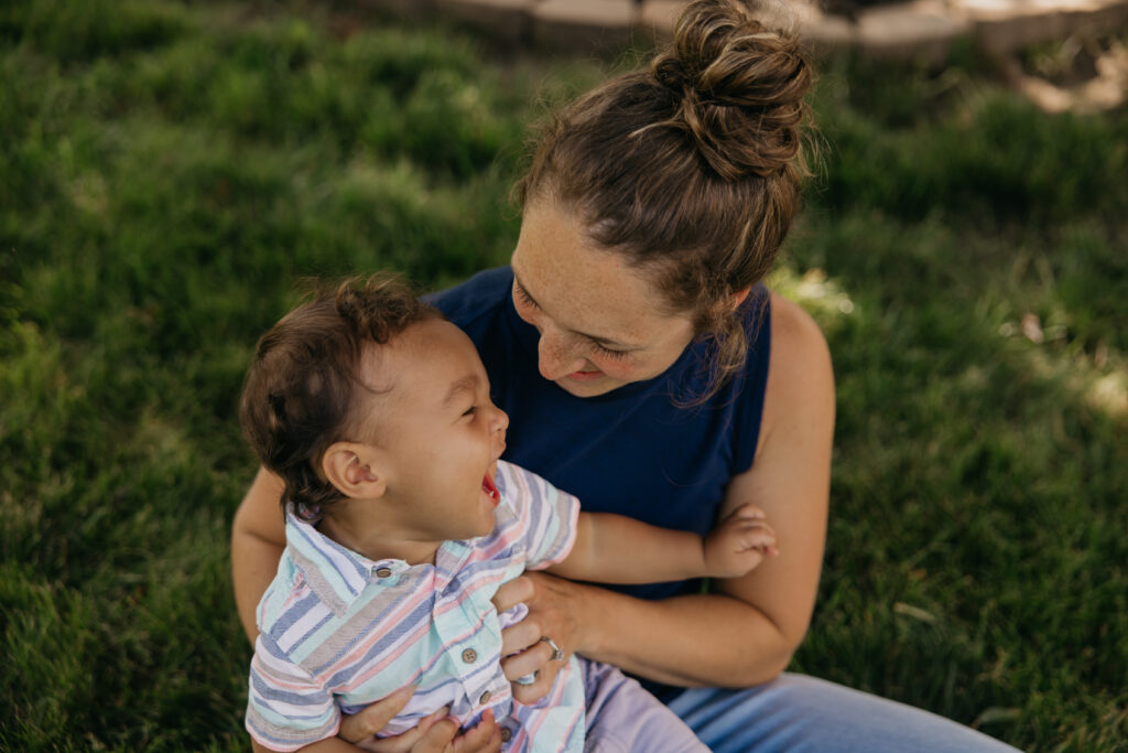 Close-up of mom and baby laughing together, faces close, during an at-home family session