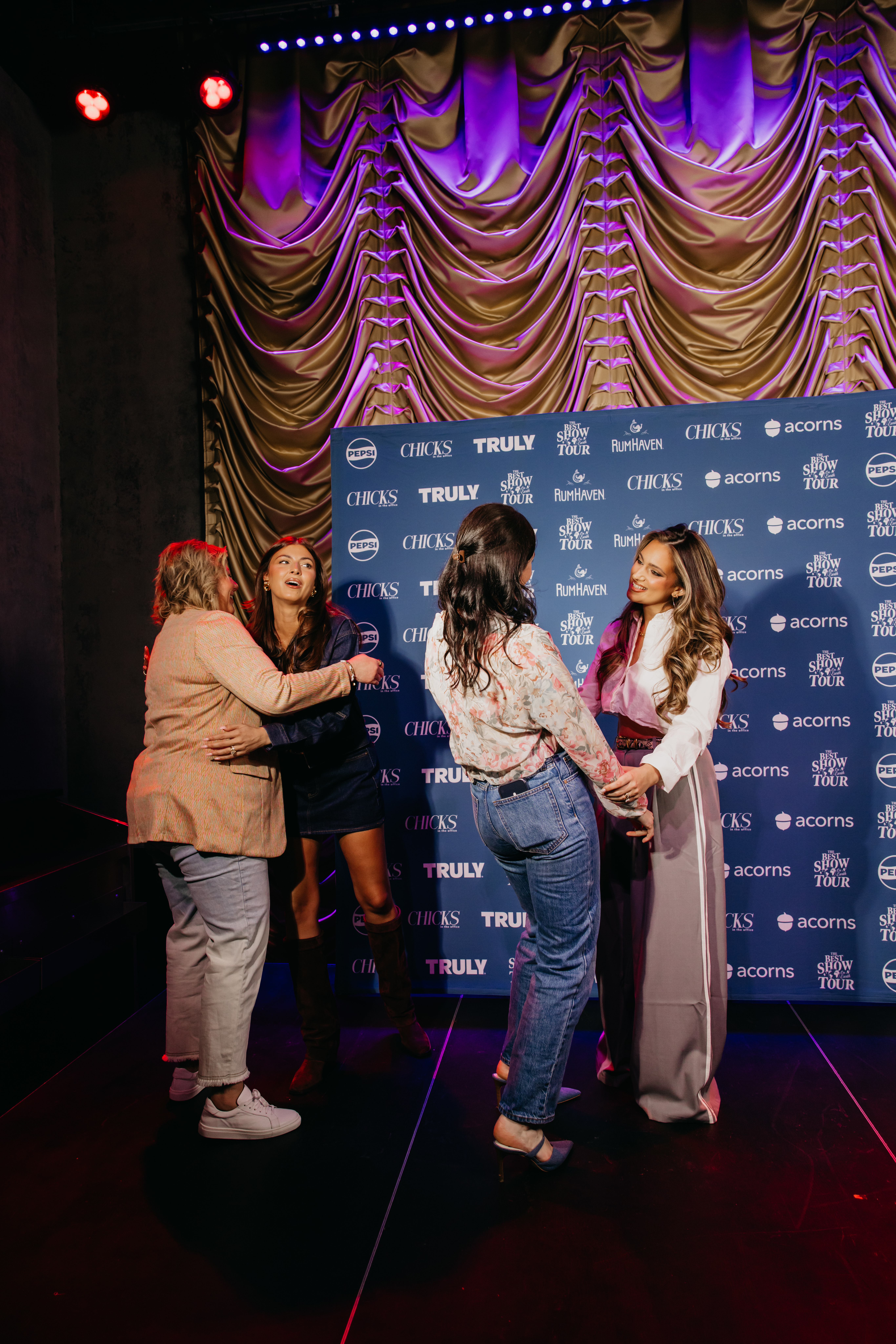 Women greeting at a sponsor step-and-repeat, corporate event photography at Chicks in the Office tour