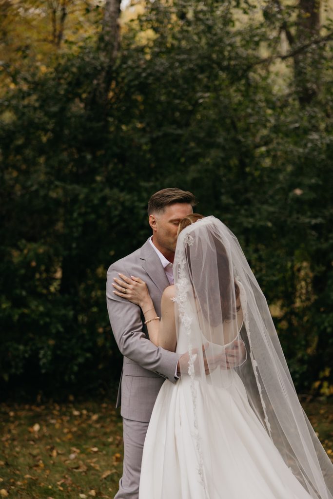 Seth and Stephanie embracing in the woods, her veil falling down her back