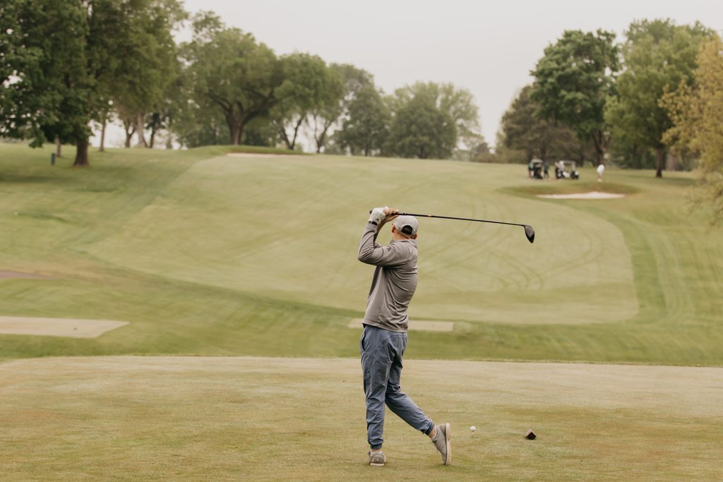 Golfer finishing his swing on the fairway